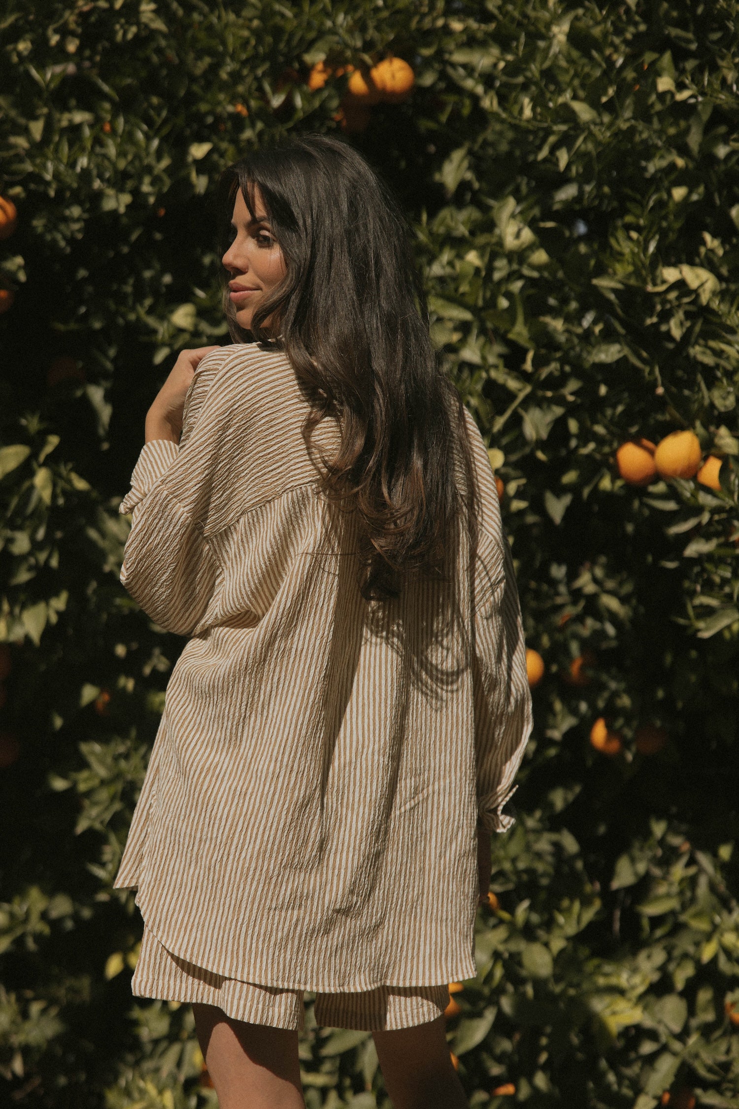 Striped long sleeve matching shorts and top beachwear set for women.