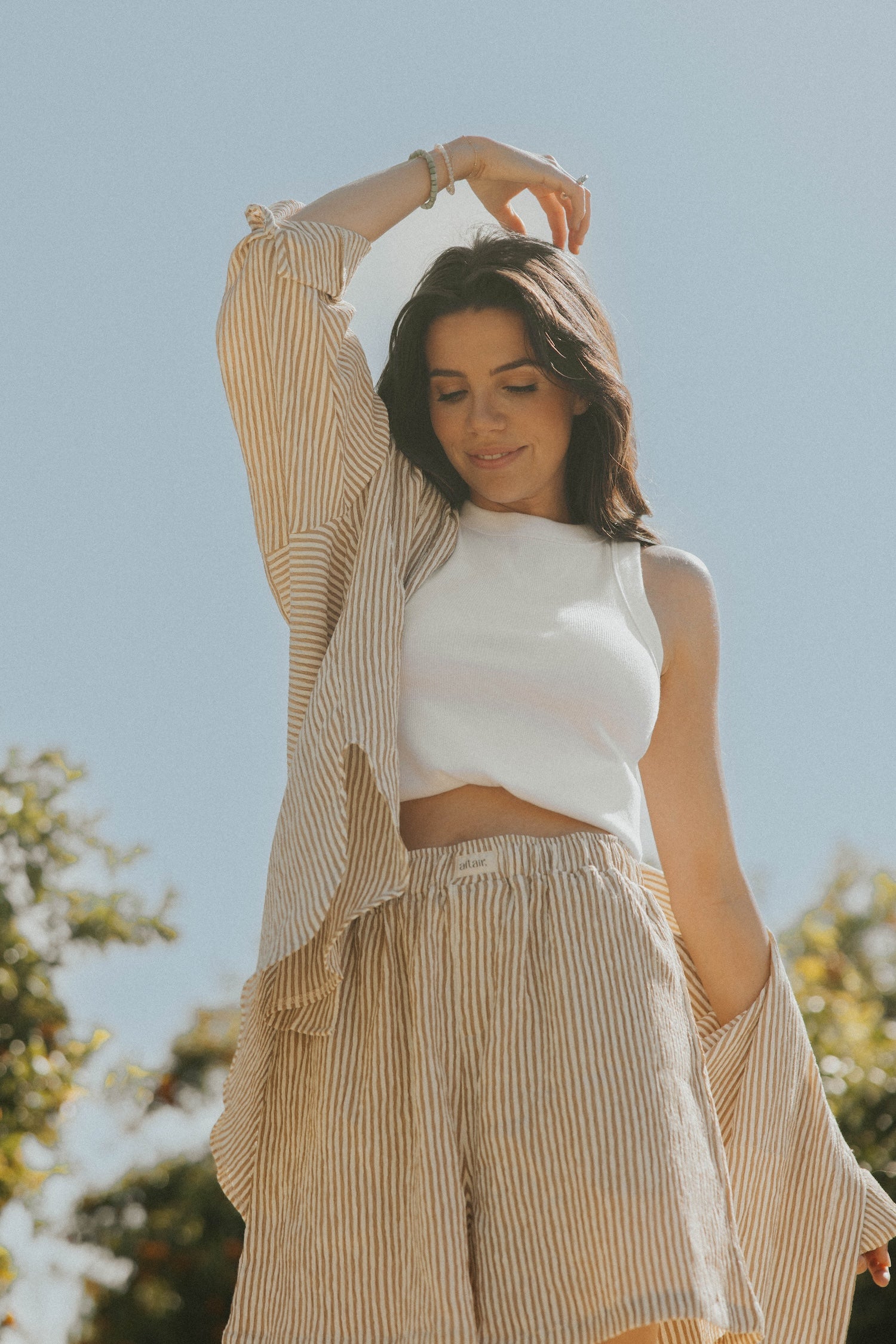 Striped long sleeve matching shorts and top beachwear set for women.