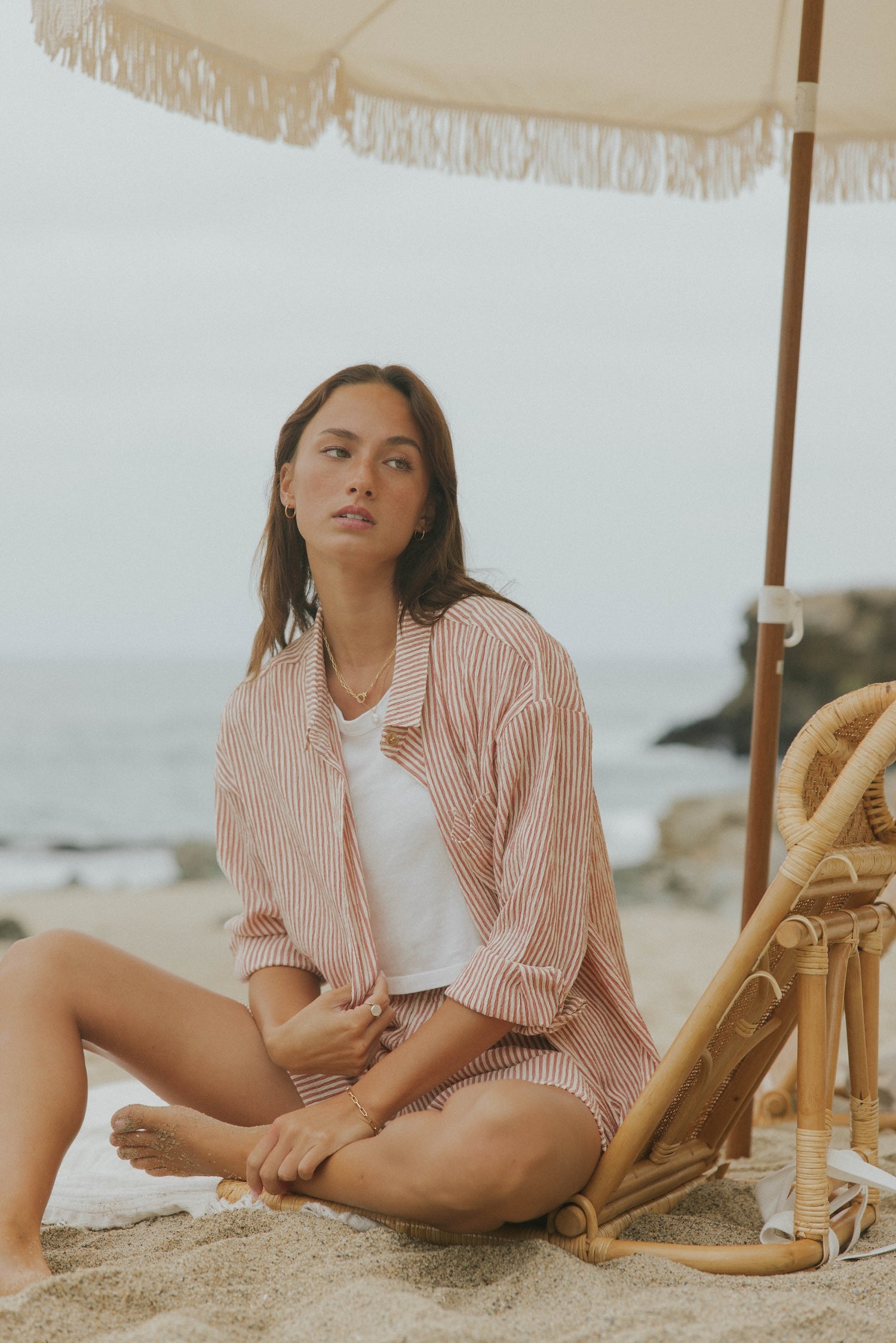 Striped long sleeve matching shorts and top beachwear set for women.